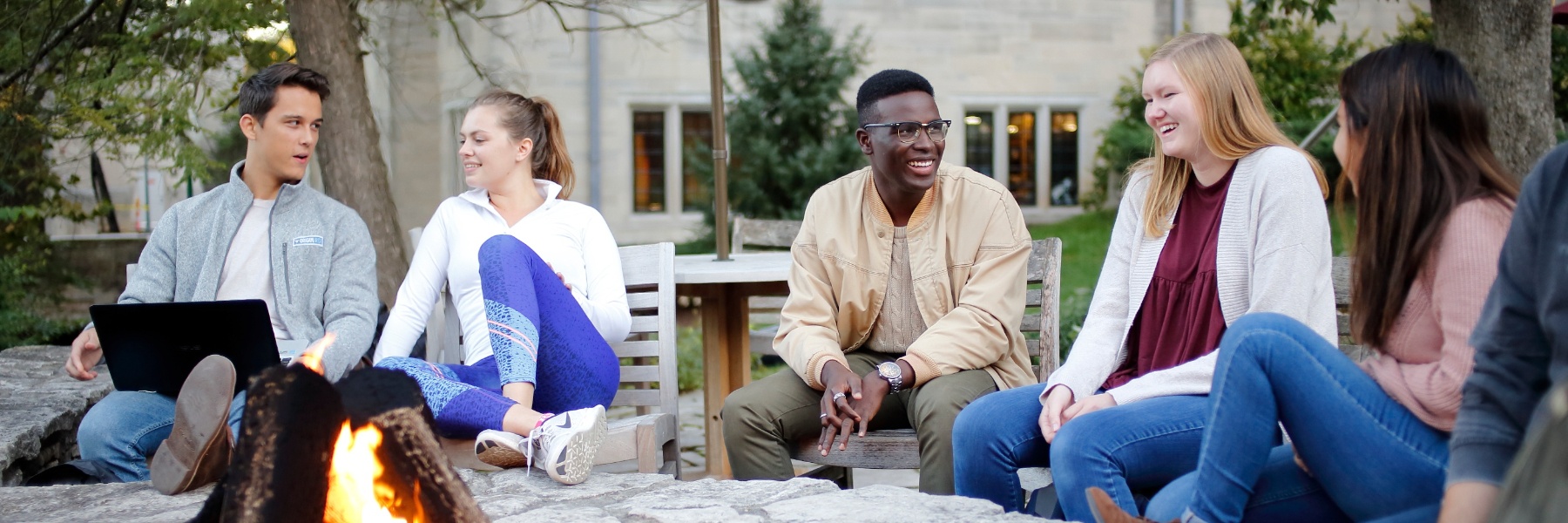 A group of students talking while sitting around the fire pit outside the Indiana Memorial Union